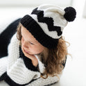 a photo showing a young girl wearing the black and white charlie brown beanie, in a slouchy, relaxed style.