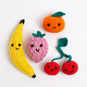 A collection photo showing Cherie the Cherries in Red Apple, Nana the Banana in Daisy Yellow, Beryl the Raspberry in Rose Pink and Clem the Satsuma in Deep Orange, all with a welcoming smiling face on a white background