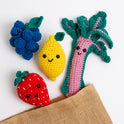 4 smiling fruits - Aubrey the Strawberry, Merlot the Grape, Lemmy the Lemon and Bard the Rhubarb are cheekily escaping from a jute bag.