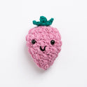 A Raspberry toy made with Stitch & Story Cotton One in Rose Pink has a joyful smiley face, with bumpy raspberry texture all around its pink body, with a Forest Green stalk at the top, on a white background