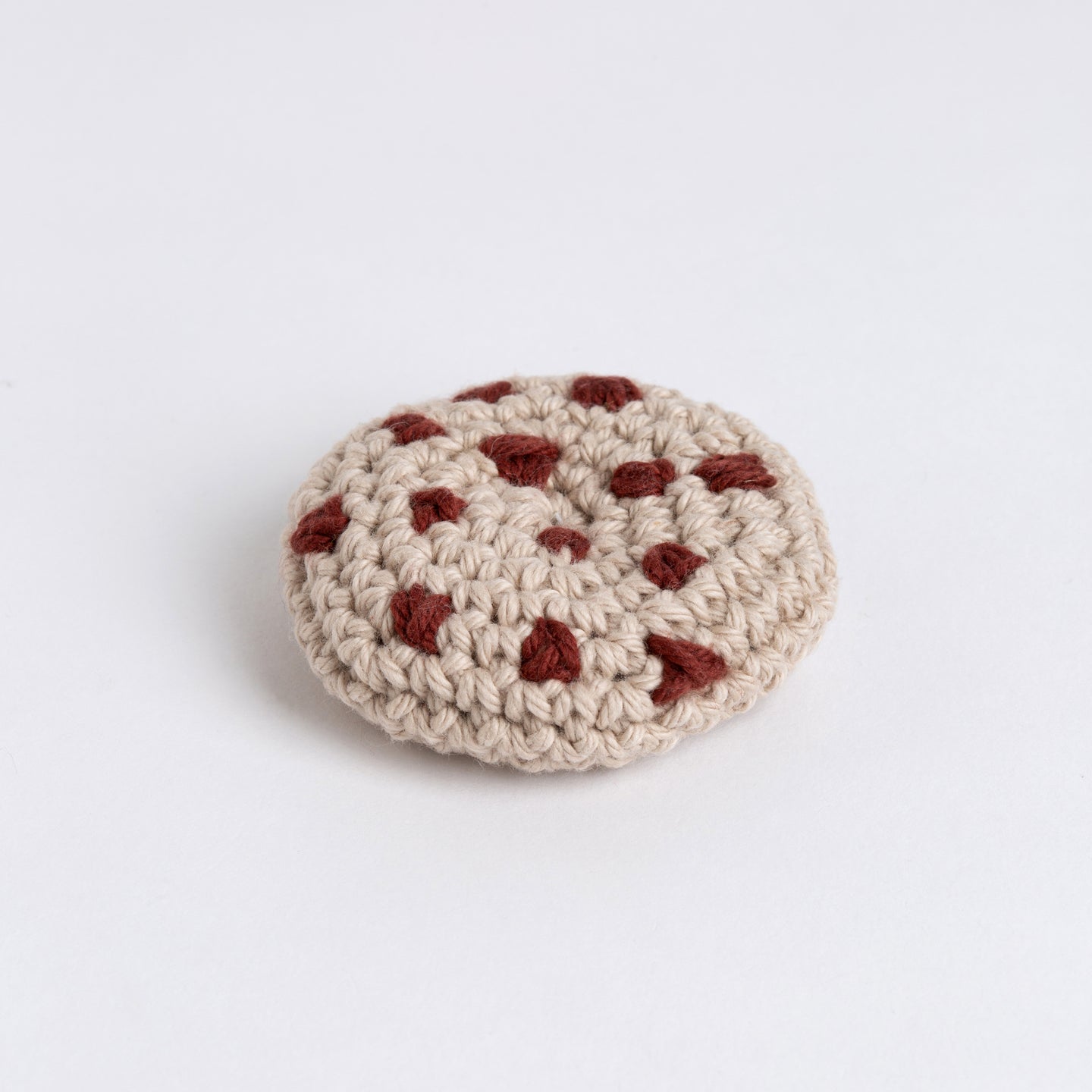 An overhead photo showing the crochet chocolate chip cookie using brown and light grey Cotton One yarn from Stitch & Story.