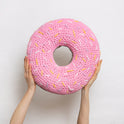 Someone is holding high up a giant round ring pink plush cushion with yellow, lilac and white sprinkles, all made with Stitch & Story Roly Poly Plush. 