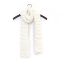 A Super chunky knitted scarf is hanging on a hanger on the wall. This is the scarf made with Stitch & Story's Grazier Scarf Knitting Kit, in 100% merino Chunky Wool