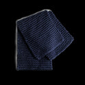 A folded Grazier Scarf in Midnight Blue, knitted from Stitch & Story's Grazier scarf beginner knitting kit.