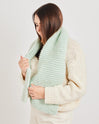 Someone is wrapped up cosily in Stitch & Story's Grazier chunky wool scarf in Iced Mint, knitted from the 100% merino Chunky Wool included in the knitting kit.