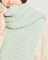 Someone is wrapped up cosily in Stitch & Story's Grazier chunky wool scarf in Iced Mint, knitted from the 100% merino Chunky Wool included in the knitting kit.