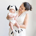 An woman is holding a baby lovingly and the baby is wearing a Snoopy beanie with flappy ears, and matching Snoopy baby booties, a knitting kit from Stitch & Story made with 100% merino wool.