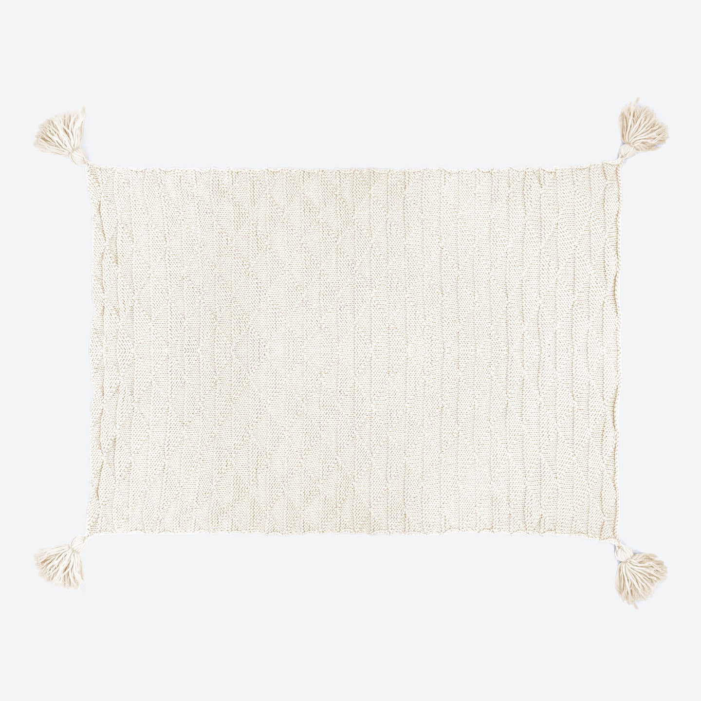 A Bright White ivy geometric blanket laid out, with all 4 corner tassels spread out.