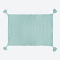 A soft teal ivy geometric blanket laid out, with all 4 corner tassels spread out.