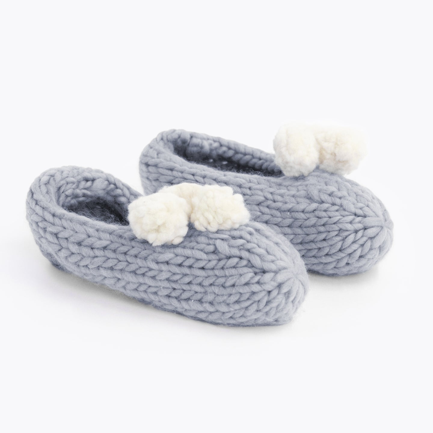 Stormy Grey lola pom slippers with white pom pom knitted from Stitch & Story beginner knitting kit