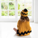 Showing the back of a girl wearing the Mustard yellow and black Charlie Brown sweater, matching the Yellow and black charlie brown hat, both knitting kits from Stitch & Story.